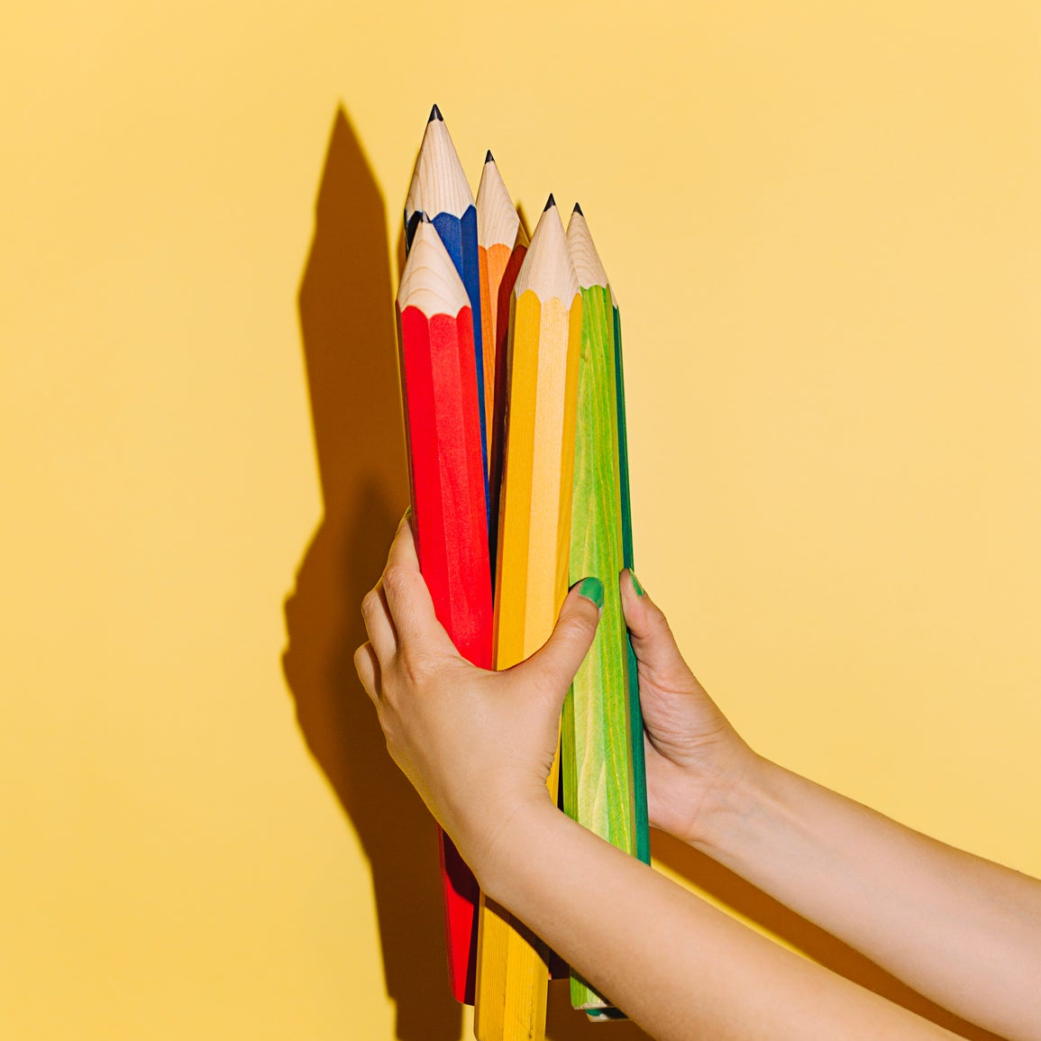Buntstifte in Kinderhänden als Symbol für spielerisches Lernen, Kreativität und Entwicklung