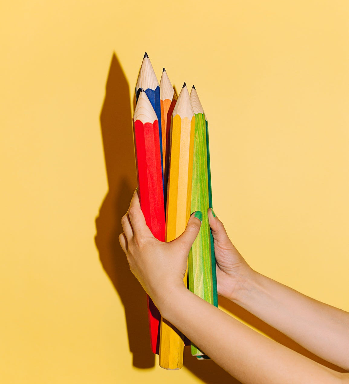Buntstifte in Kinderhänden als Symbol für spielerisches Lernen, Kreativität und Entwicklung