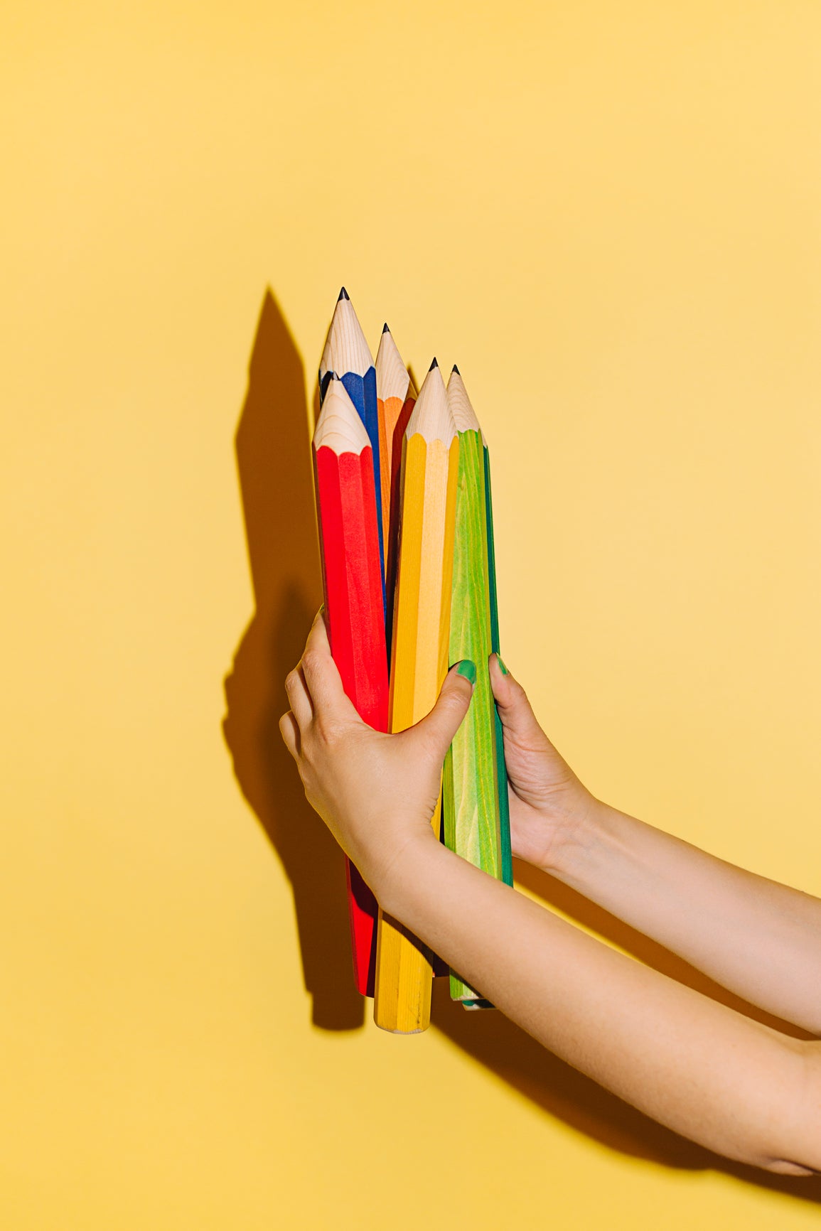 Buntstifte in Kinderhänden als Symbol für spielerisches Lernen, Kreativität und Entwicklung